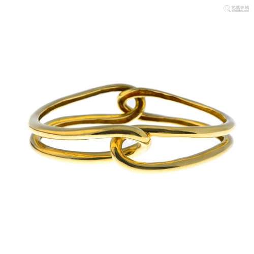 CARTIER - an 18ct gold bangle. Of openwork design,