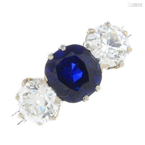 A sapphire and diamond three-stone ring. The
