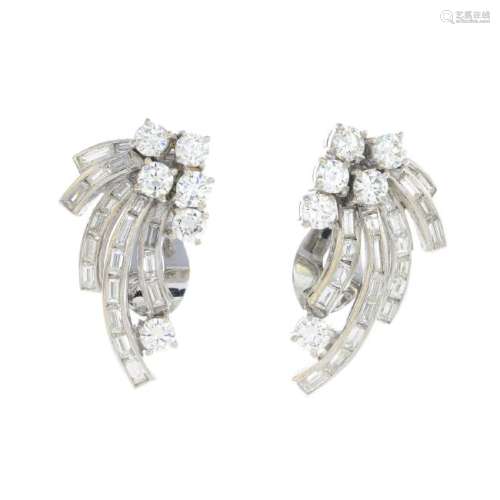 A pair of diamond earrings. Each designed as a series