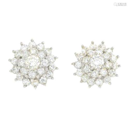 A pair of diamond cluster earrings. Each designed as a