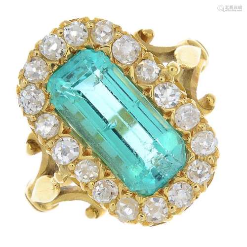 An emerald and diamond cluster ring. The cushion-shape