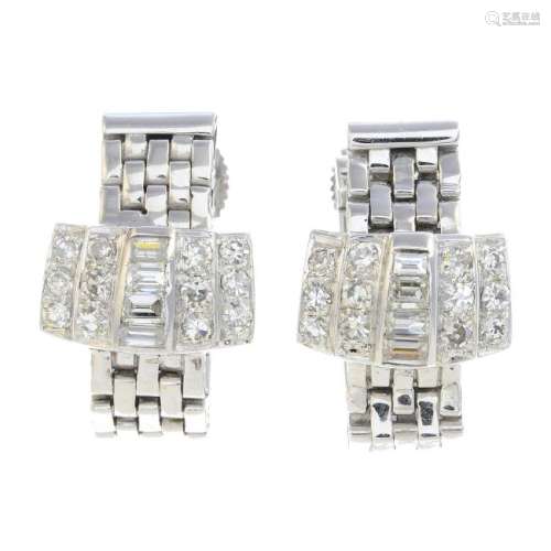 A pair of diamond earrings. Each designed as a