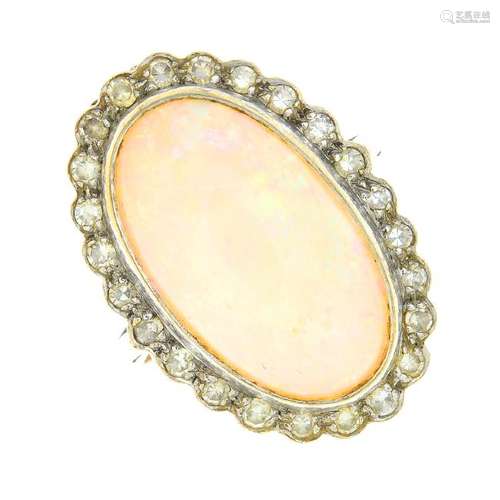 An opal and diamond cluster ring. The oval opal