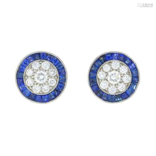 A pair of diamond and sapphire earrings. Each designed