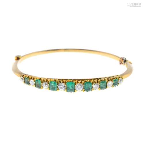 An emerald and diamond hinged bangle. Designed as an