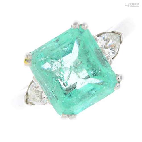 An 18ct gold emerald and diamond three-stone ring. The