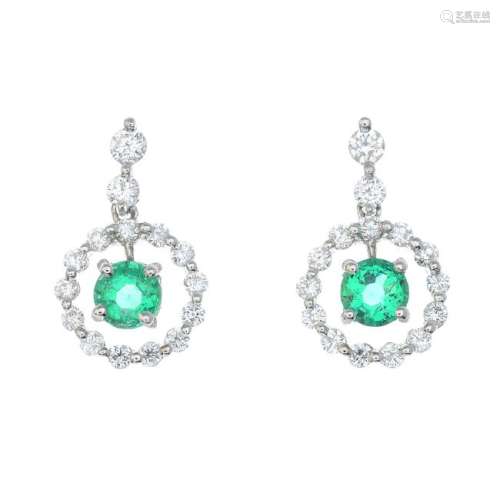 A pair of emerald and diamond earrings. Each designed
