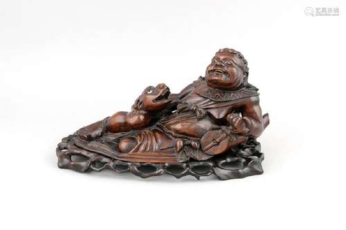 A Chinese figure of a reclining man with creature, 20th