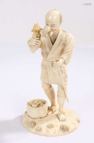 Japanese Meiji period ivory Okimono, carved as a fruit seller holding a stick, signed to the base