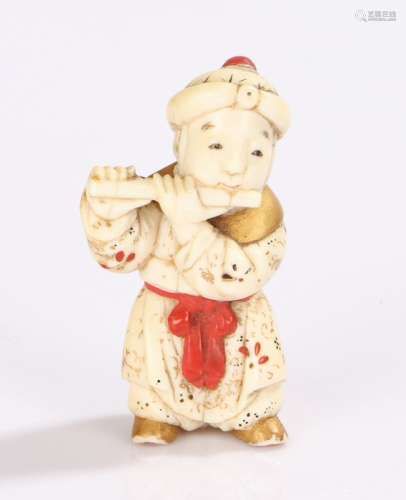 Japanese Meiji period ivory netsuke, carved as a boy playing a flute with gilt and red lacquer