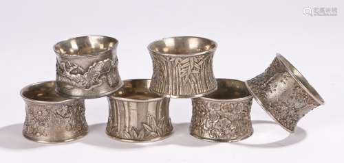 Collection of Chinese white metal napkin rings, decorated in various styles with dragons, bamboo,
