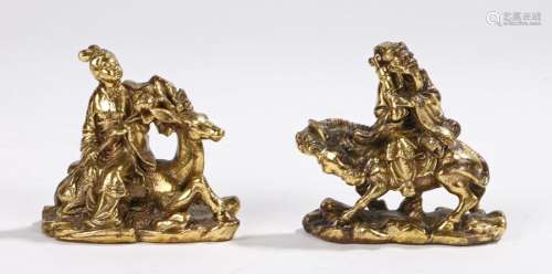 Pair of Chinese gilt bronze figures, depicting a lady seated on a stag and a gentleman seated on a