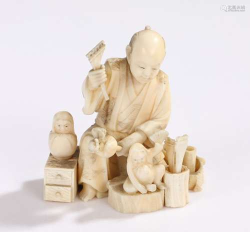 Japanese Meiji period ivory Okimono, carved as a daruma toy maker with tools and drawers