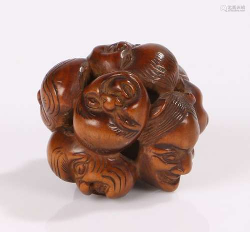 Japanese Meiji period netsuke, the netsuke of carved boxwood and in the form of a group of masks,