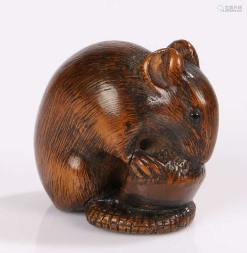 Japanese Edo period netsuke, the boxwood netsuke carved as a mouse eating a nut, it's tail curled