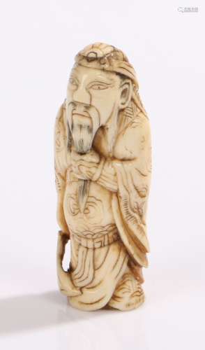 Japanese Meiji period ivory netsuke, carved as a samurai holding a weapon to his left arm, 6.5cm