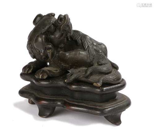 Japanese meiji period Shishi. the Shishi laying down, curled up scratching an ear, on a wooden