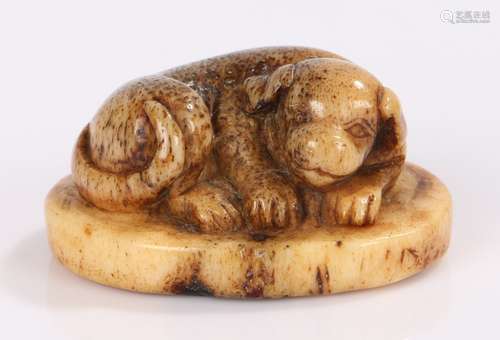 Japanese Edo period netsuke, the stag antler netsuke carved as a reclining dog, signature to the