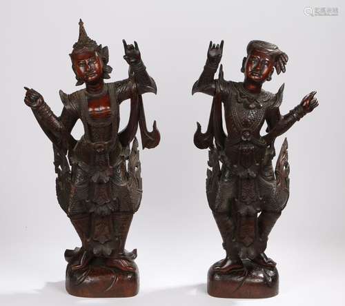 Pair of carved wooden deity figures, depicted with their hands raised, the largest 67cm high