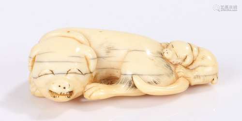 Japanese Edo period netsuke, the ivory netsuke carved as a reclining dog and puppy, 6cm long