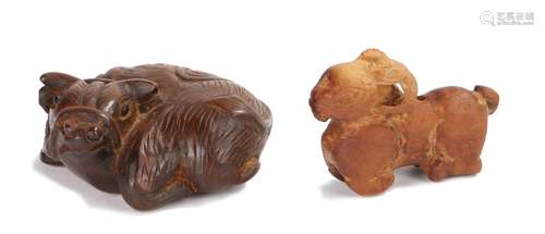 Two Japanese wood netsuke, the netsuke carved as an ox laying down and a goat, the ox 5cm diameter