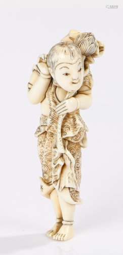 Japanese Meiji period netsuke, the ivory netsuke depicting a standing boy holding a lotus flower