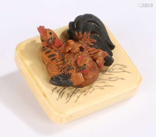 Japanese Meiji period ivory and boxwood netsuke, the carved hen with chicks above the ivory panel