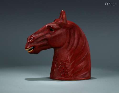 A carved cinnabar head of horse ornament