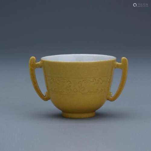 A carved yellow glazed cup; Kangxi mark