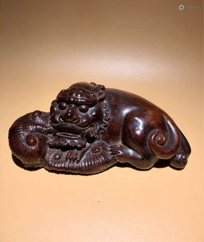 A RED WOOD CARVED BEAST PENDANT