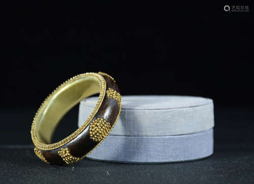 A GILT SILVER WOOD BANGLE