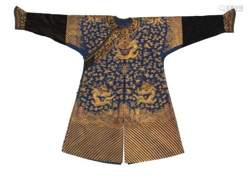 A Chinese blue silk dragon robe, late 19th / early 20th century, worked in couched gold threads with