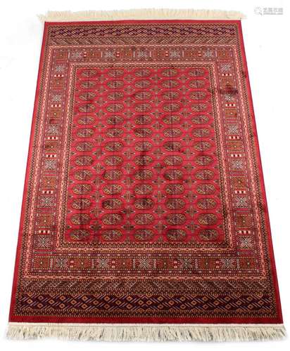 A Bokhara style rug with red ground, 75 by 53ins. (190 by 135cms.) (see illustration).