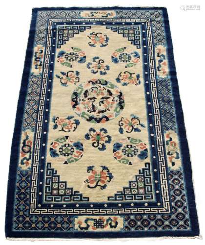 A mid 20th century Chinese wool rug, with ivory field within navy borders, 85 by 53ins. (216 by