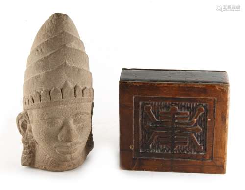 A fragmentary stone Buddha head, 11.6ins. (29.5cms.) high; together with a wood block pillow with