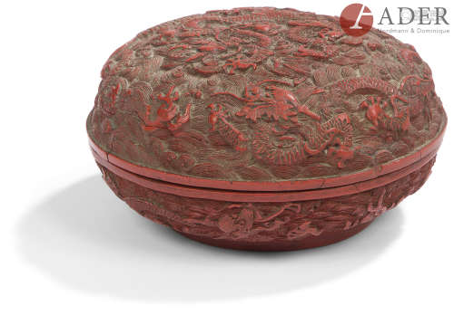 CHINE - XIXe siècle Boîte ronde en laque rouge à décor sculpté en relief de dragons à cinq griffes