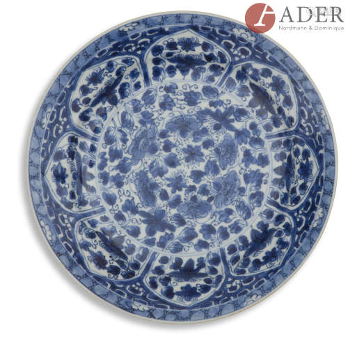 CHINE - Époque KANGXI (1662 - 1722) Assiette en porcelaine bleu blanc à décor de fleurs dans leur