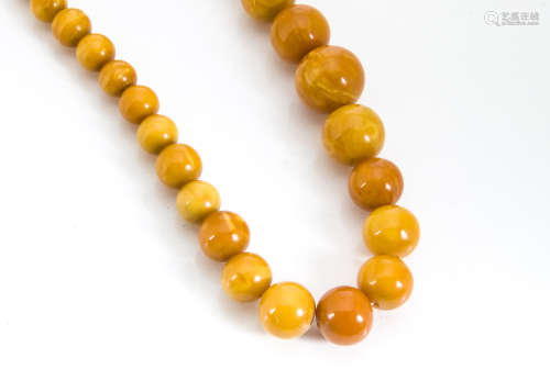 An amber graduated bead necklace, the toffee coloured beads with screw clasp, 59g, largest bead 19.