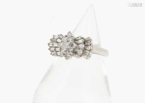 A contemporary art deco style diamond and white metal set dress ring, centred with a cluster of