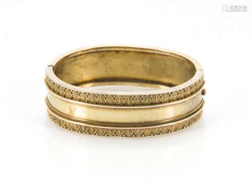 A Victorian gold bangle, oval form with one half plain, the other with neo-classical design, 23.
