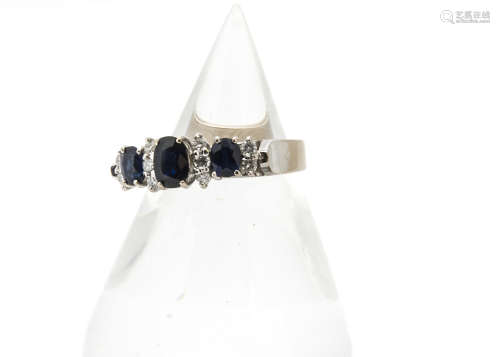 An 18ct gold contemporary sapphire and diamond dress ring, the three oval mixed cut blue stones with