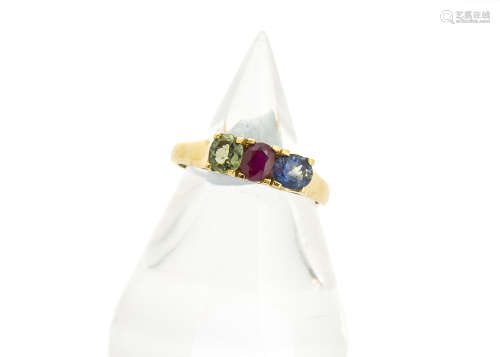 A continental yellow metal and three stone set dress ring, set with sapphire, ruby and green