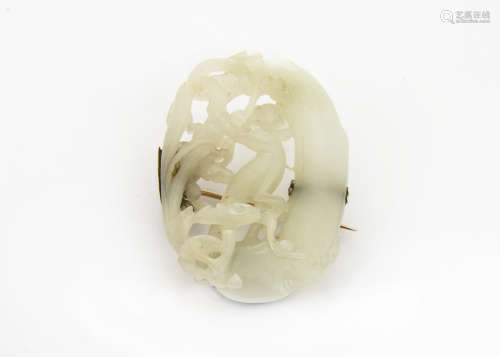 A late 19th Century Chinese jade brooch, the oval carved and pierced light coloured hardstone