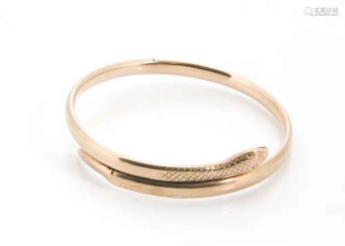 An early 20th Century 9ct gold serpent bangle, by Saunders and Shepherd, with engraved head and