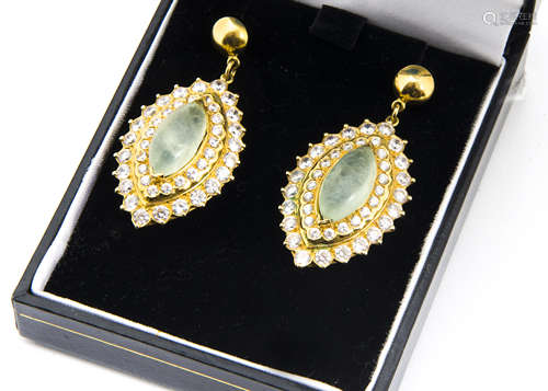 A pair of yellow metal gem set oval pendant drop earrings, centred with a pair of cabochon oval