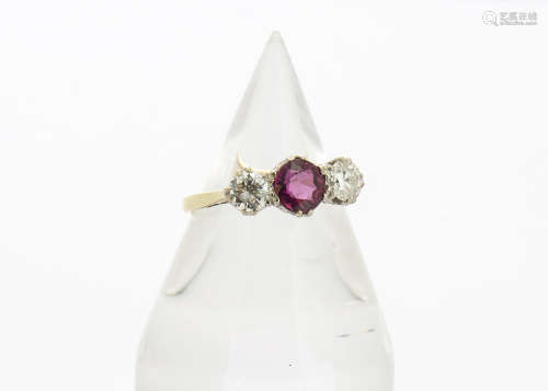 A ruby and diamond three stone ring, the circular mixed cut ruby flanked by two brilliant cut