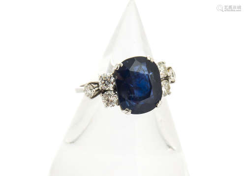 A sapphire and diamond 18ct gold dress ring, the oval mixed cut sapphire in four claw setting set