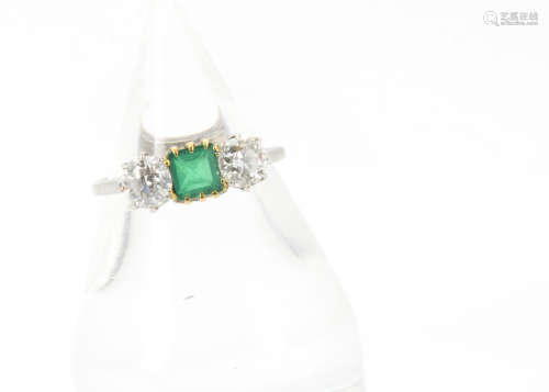 An Edwardian period three stone emerald and diamond ring, the central square cut emerald flanked