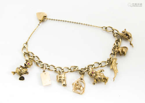 A 9ct gold curb linked charm bracelet, with eight gold charms including Donald Duck, a mouse trap,