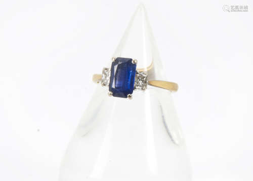 A modern 18ct gold sapphire and diamond three stone ring, central rectangular cut blue sapphire